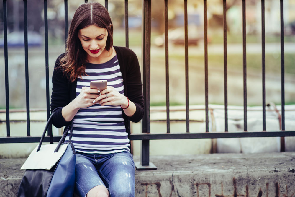 Woman views a Facebook advertisement on her mobile phone