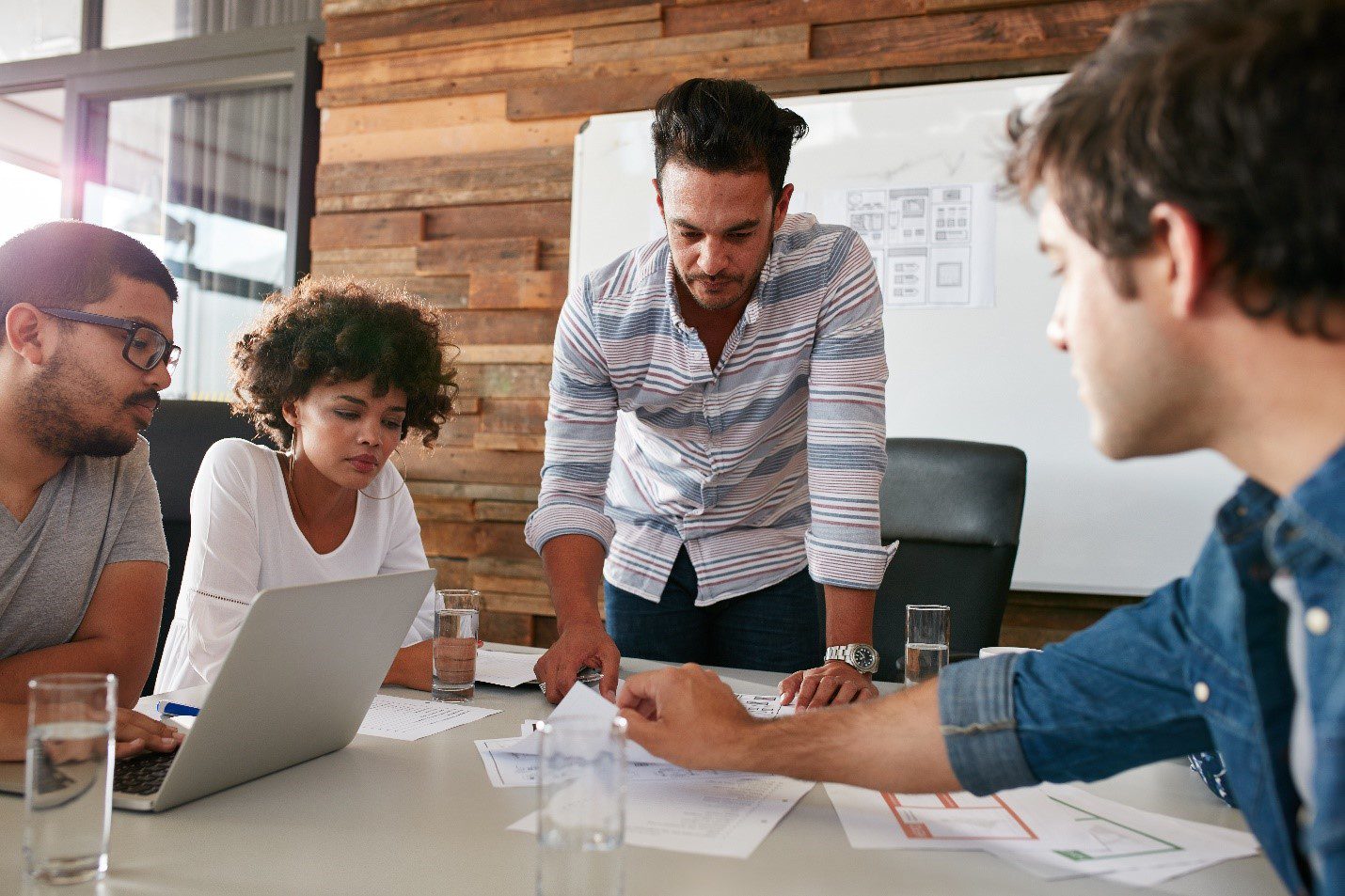 People gathered around a table looking at marketing statistics.