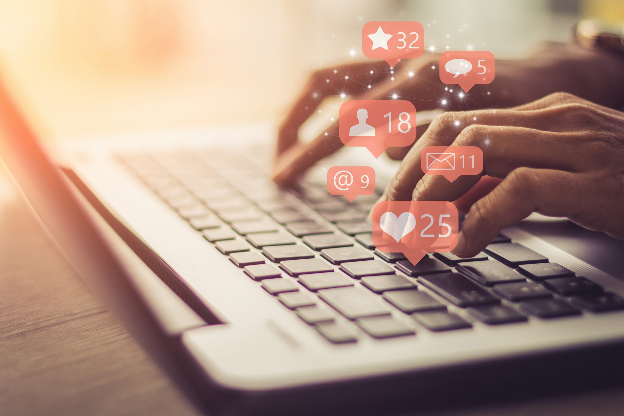 hands type on a laptop with social icon notifications graphics on top of hands